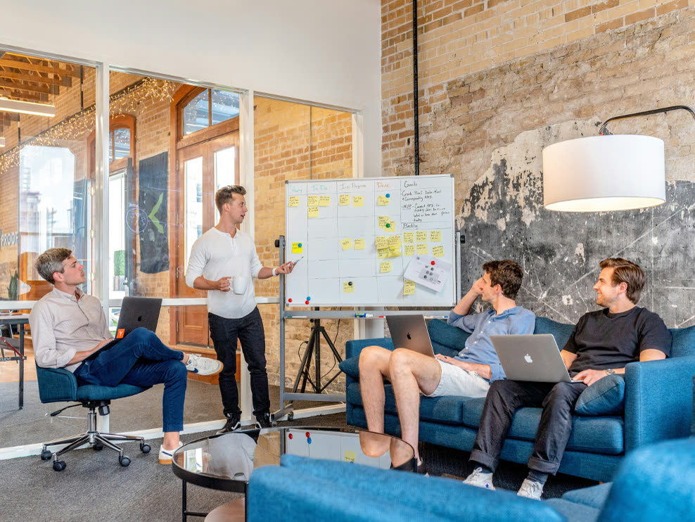 A team meeting around a whiteboard in a bright office