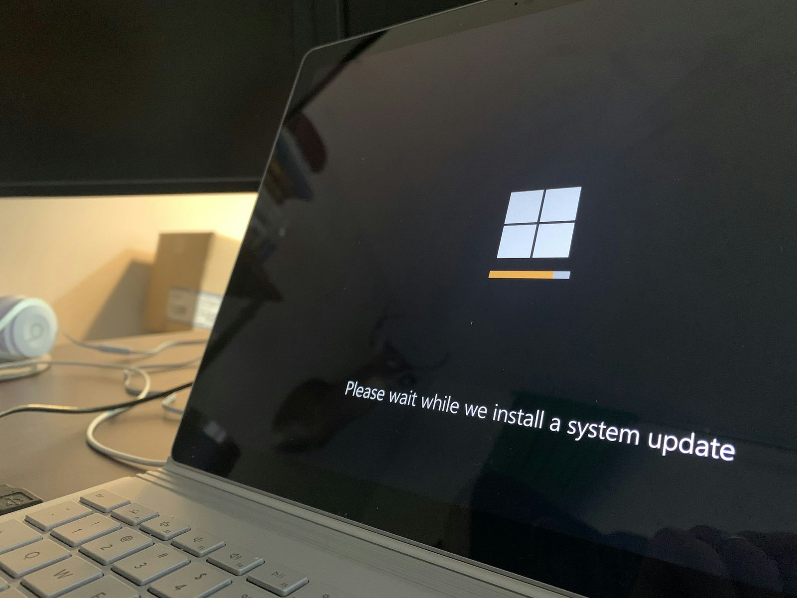 A laptop screen showing "Please wait while we install a system update"